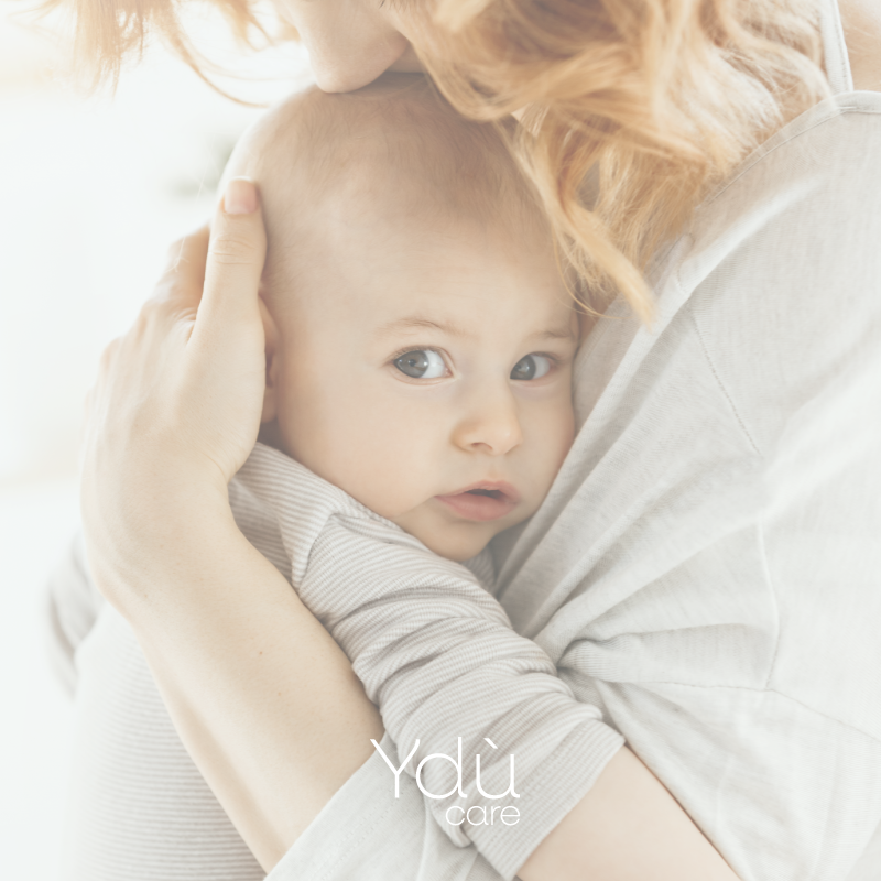 bambino con occhi grigi in braccio alla mamma