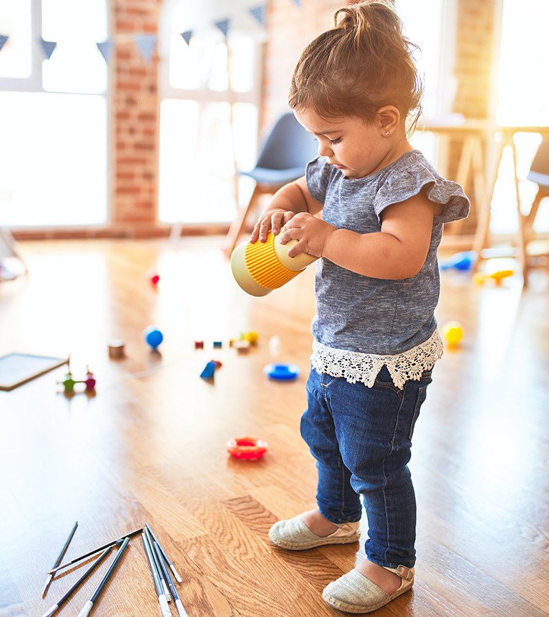 bambina monta un giocattolo con le mani
