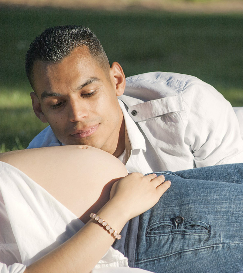 futuro papà osserva il pancione della futura mamma